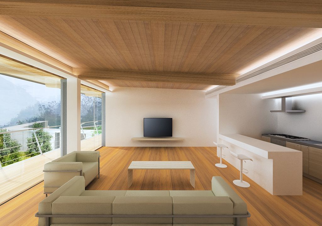 Open living space with a warm wood ceiling, cream sofas and a wide view outside