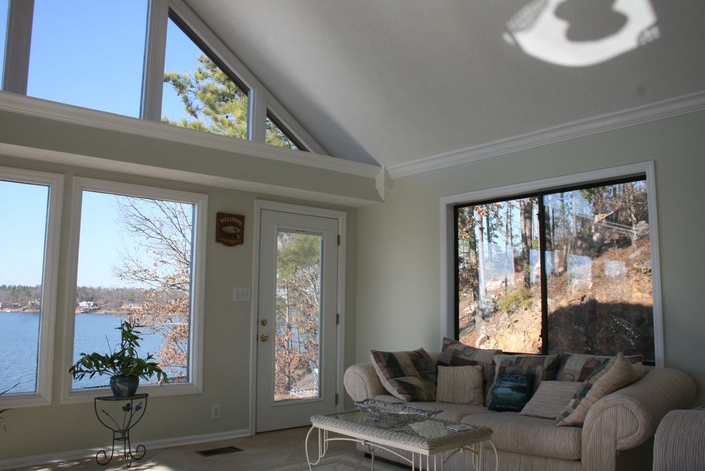 Sunny lounge with a cream sofa and glass doors overlooking the water