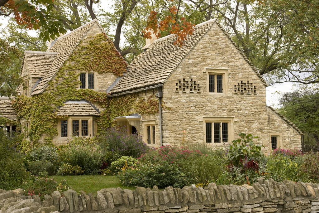 Stone cottage with ivy on the walls and a full, flowering front garden